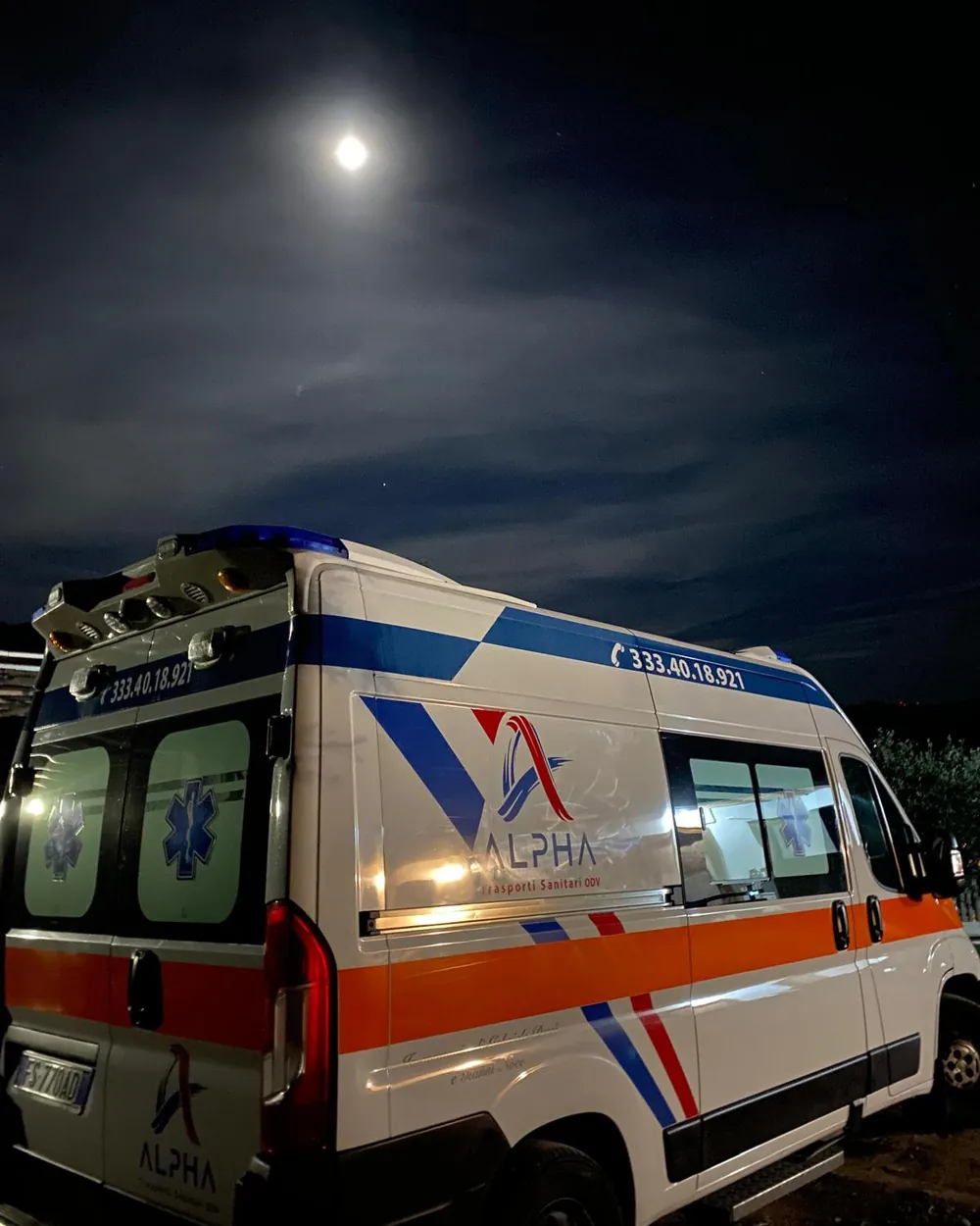 Ambulanza ALPHA pronta al servizio nella notte, con la luna sopra il mezzo illuminato
