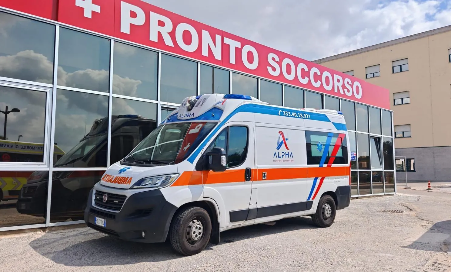 L'ambulanza ALPHA con il numero 333 401 8921 sulla fiancata, parcheggiata davanti all'ingresso del Pronto Soccorso