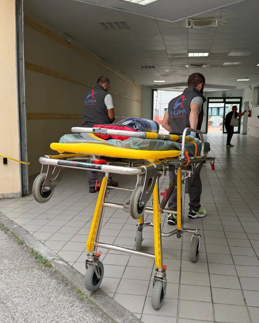 Due operatori ALPHA con la barella nel corridoio dell'ospedale durante un trasporto programmato