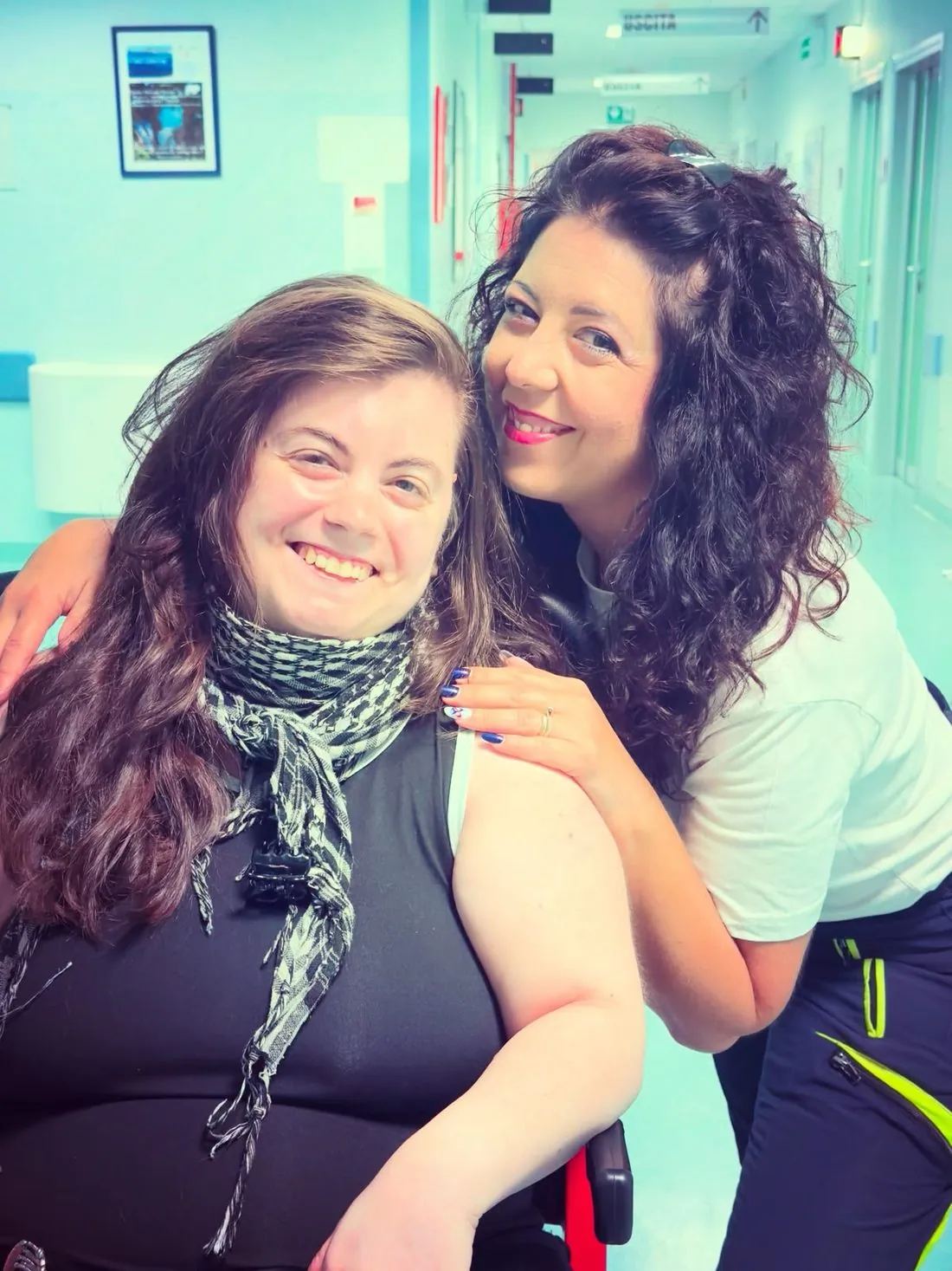 La nostra operatrice abbraccia sorridendo una paziente felice nel corridoio dell'ospedale
