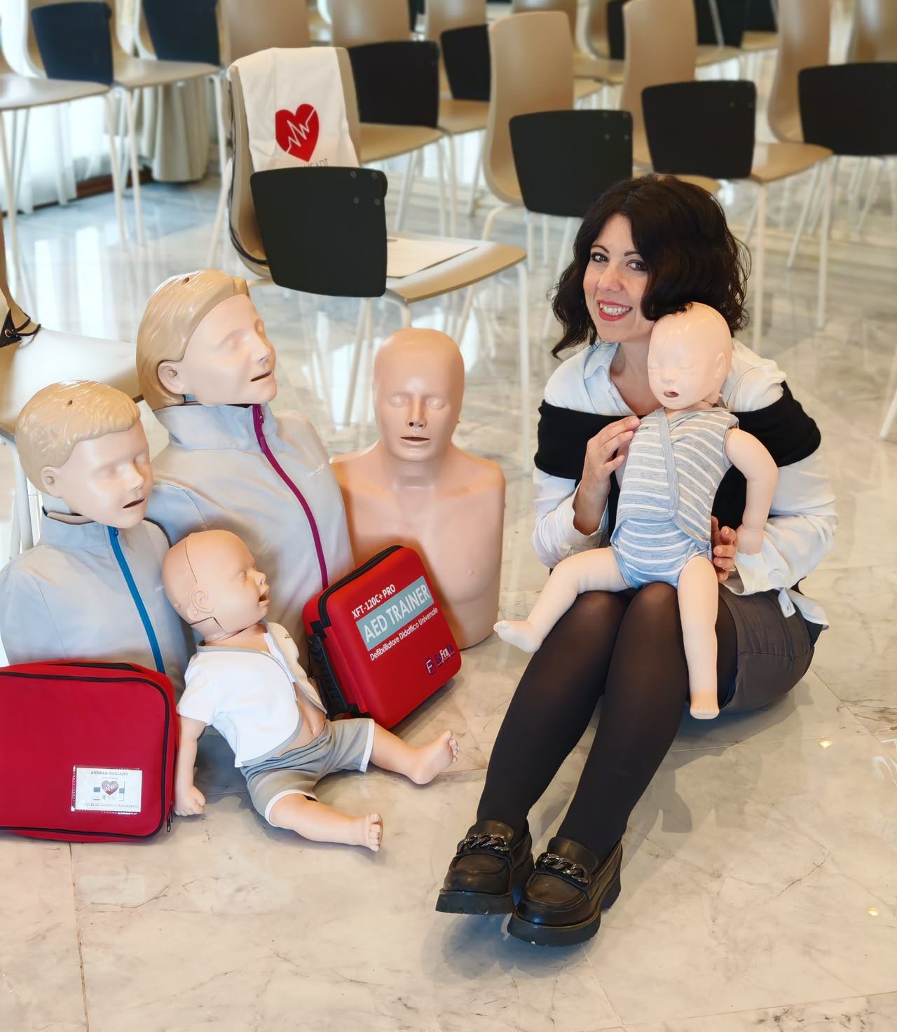 Miriam Castellano, istruttrice BasicLife, sorride tenendo in braccio un manichino neonato da esercitazione