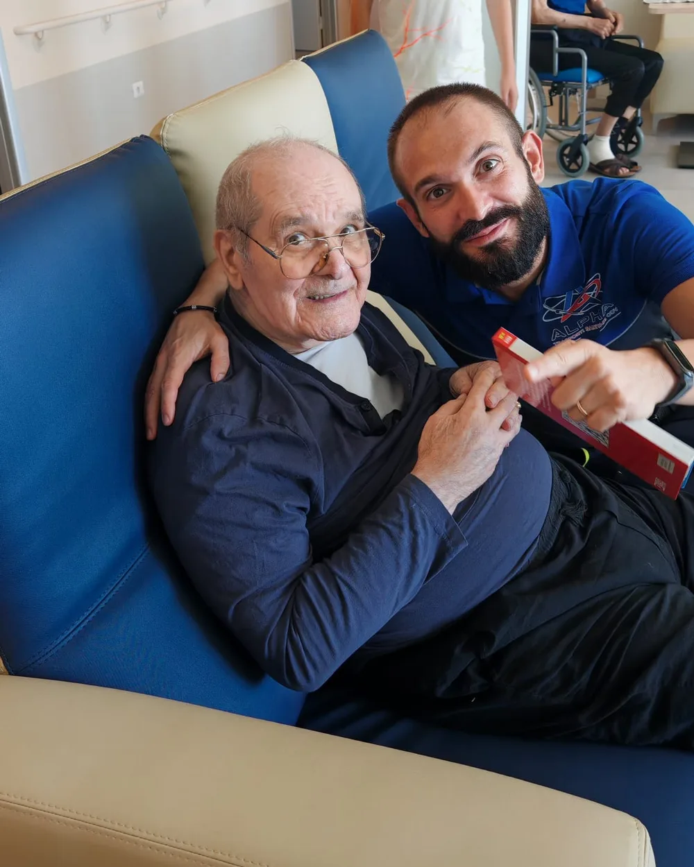 Andrea, operatore ALPHA, abbraccia sorridendo suo nonno in ospedale