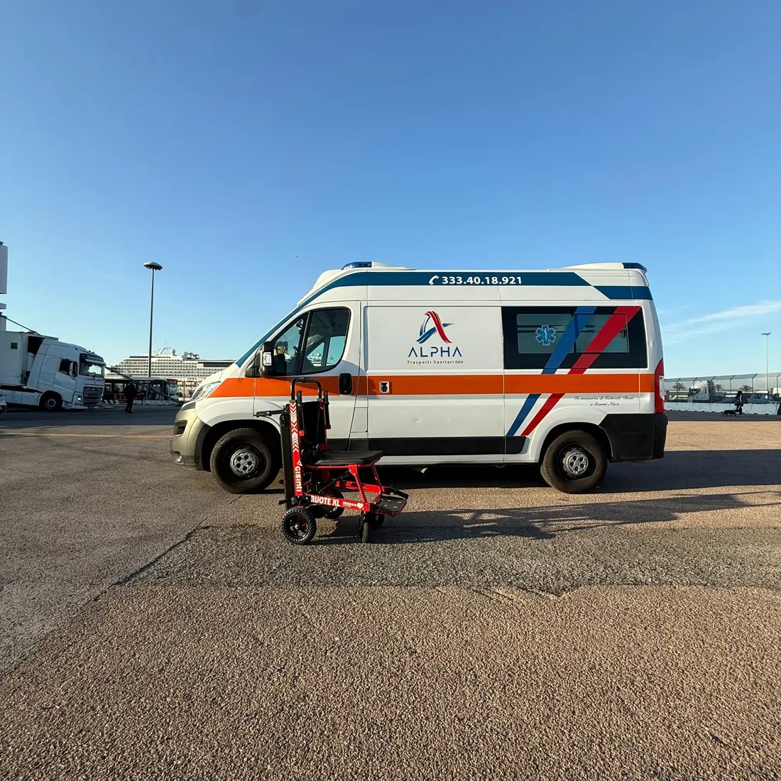 Sedia da trasporto elettrica accanto all'ambulanza ALPHA: i due mezzi tra cui scegliere per un trasporto sanitario