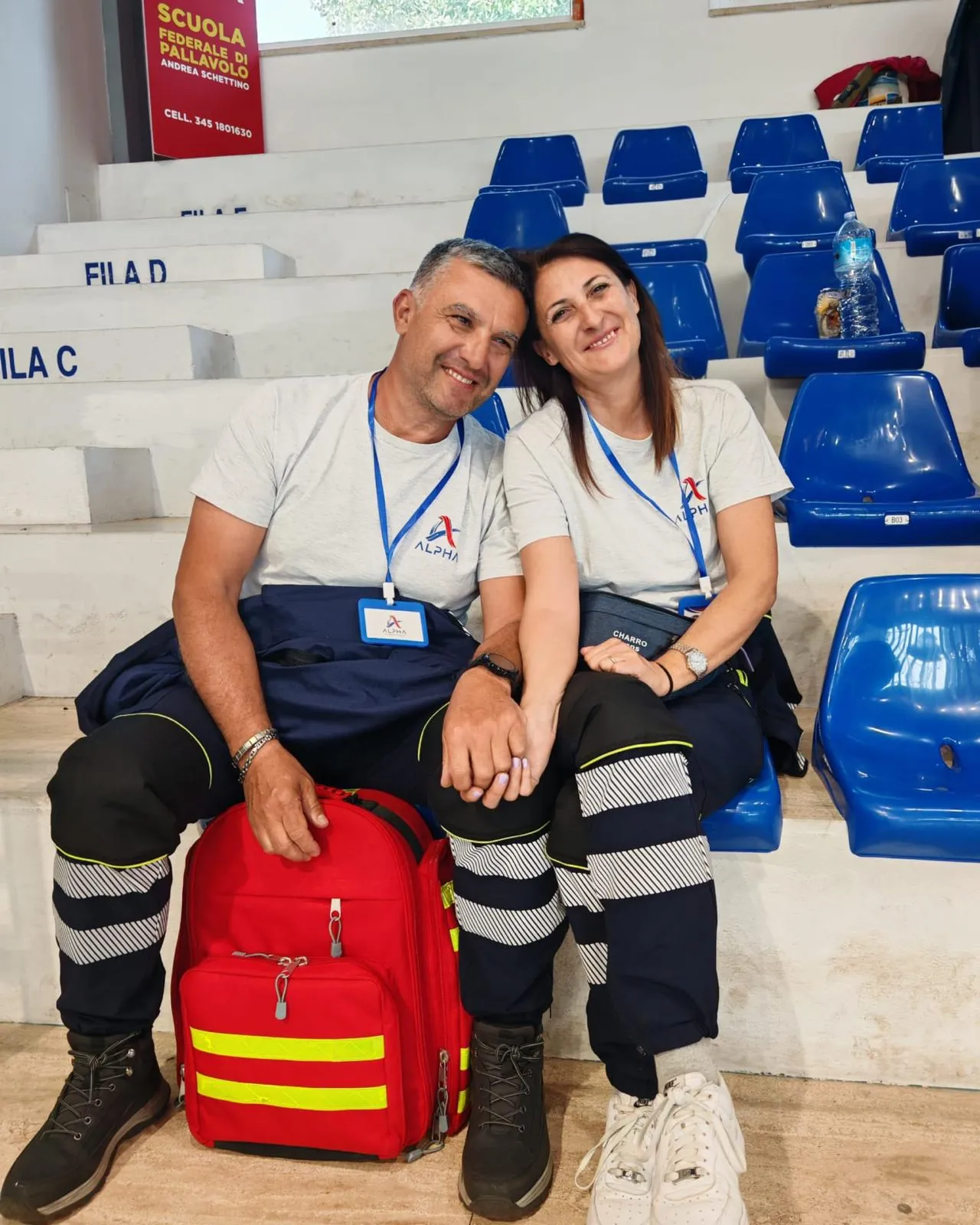Due volontari ALPHA sorridenti in divisa con lo zaino di primo soccorso