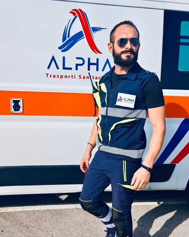Andrea, autista soccorritore ALPHA, in divisa davanti all'ambulanza