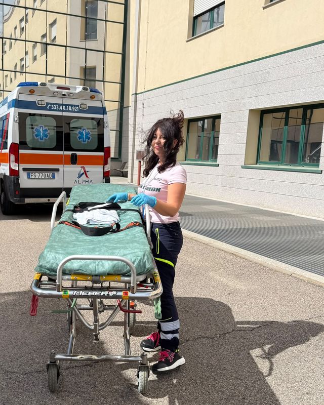 Miriam prepara la barella davanti alle ambulanze, davanti all'ospedale